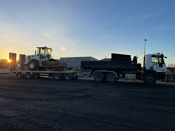 Semi benne TP transportant des matériaux et engins sur un chantier de démolition